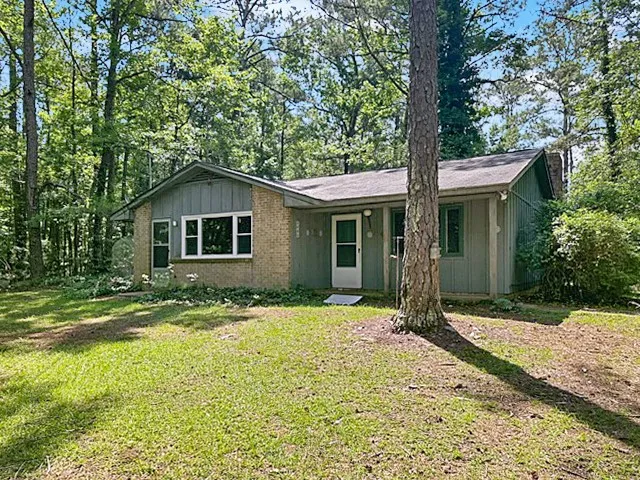 A welcoming home nestled in a wooded setting, offering a peaceful retreat.