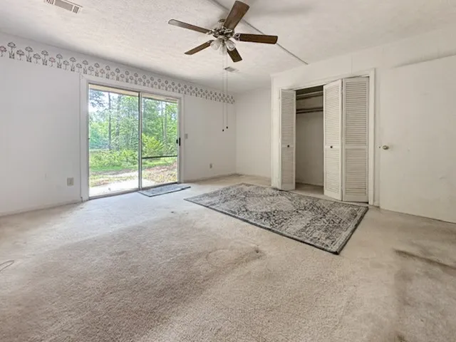 Comfortable bedroom offers a serene retreat with outdoor access and ample closet space.