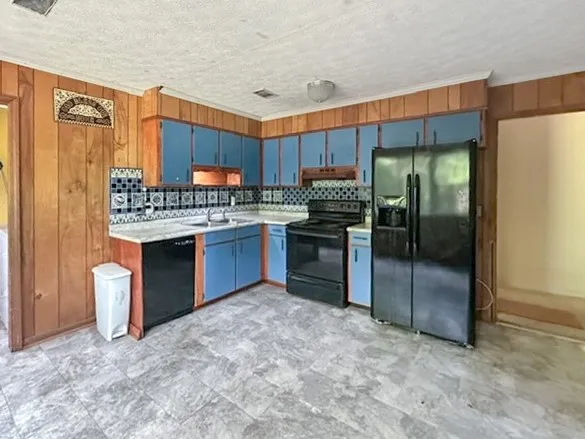 A vibrant kitchen space showcases blue cabinetry contrasted by natural wood paneling.