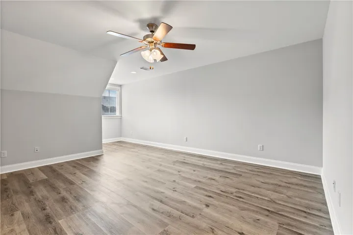 Luminous room featuring a window and a ceiling fan, offering comfortable living space.