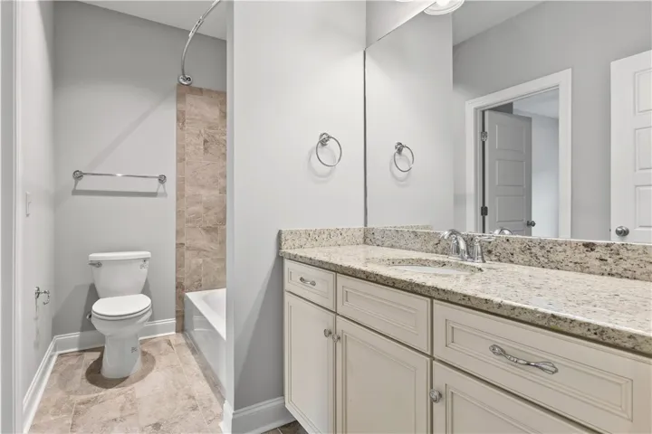 A well-appointed bath features a spacious vanity with an integrated sink and an adjacent tub/shower combination.