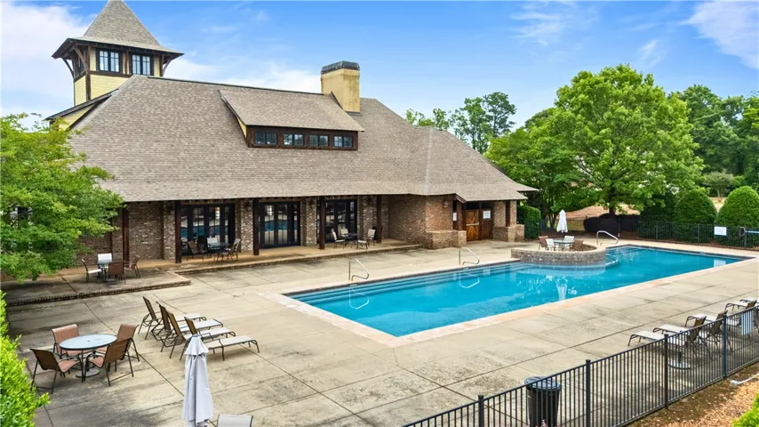 An inviting pool area awaits, set against a charming clubhouse with brick accents.