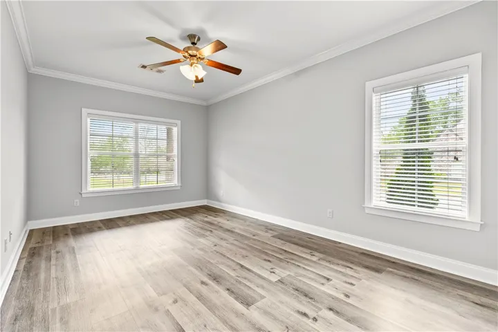 A well-lit interior space features sleek wood flooring and ample natural light from multiple windows.