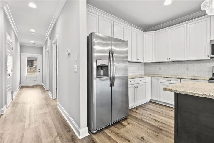 Bright, open-concept kitchen features stainless steel appliances, pristine countertops, and durable flooring.