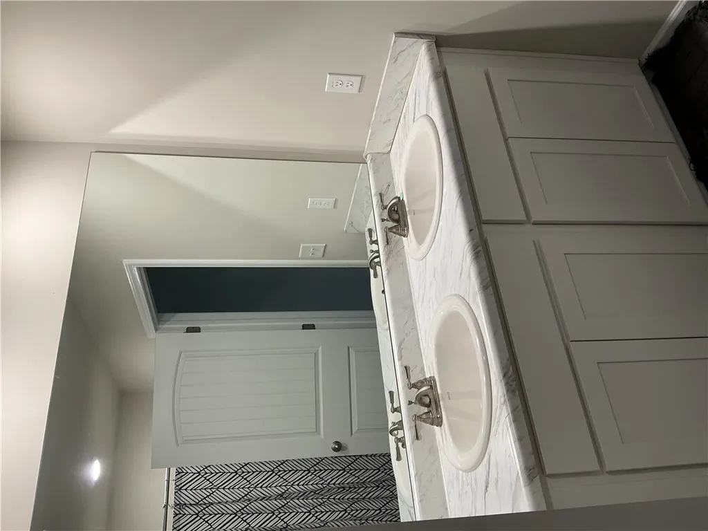 Double vanity with ample counter space and cabinet storage creates a practical bathroom.