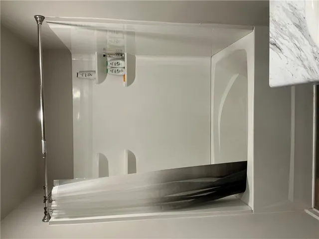 A pristine shower-over-tub combination offers comfort and utility.