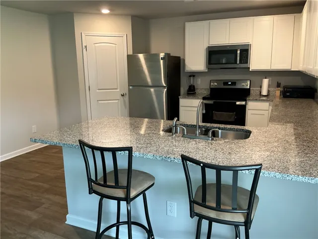 A contemporary kitchen features an inviting island with a breakfast bar, ready for casual dining.