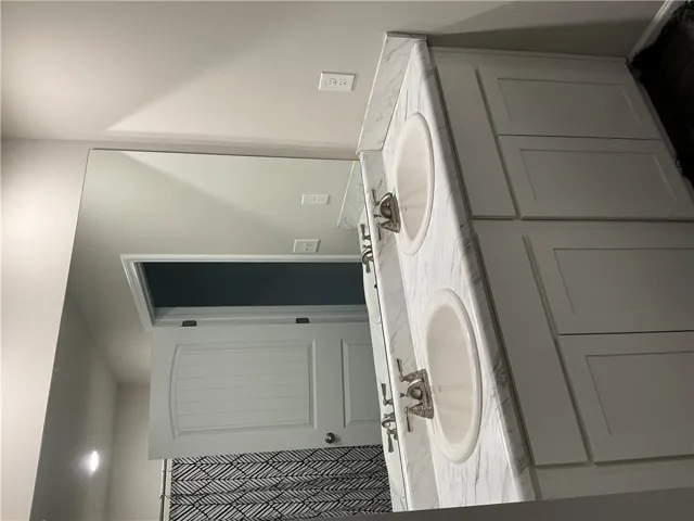 Double vanity with ample counter space and cabinet storage creates a practical bathroom.