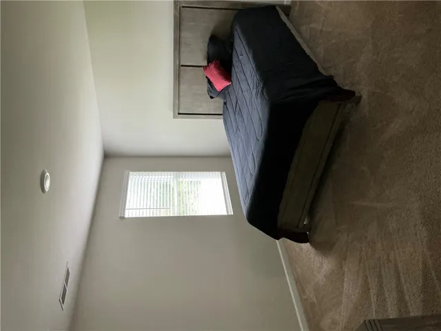 A well-lit bedroom with soft carpeting awaits.
