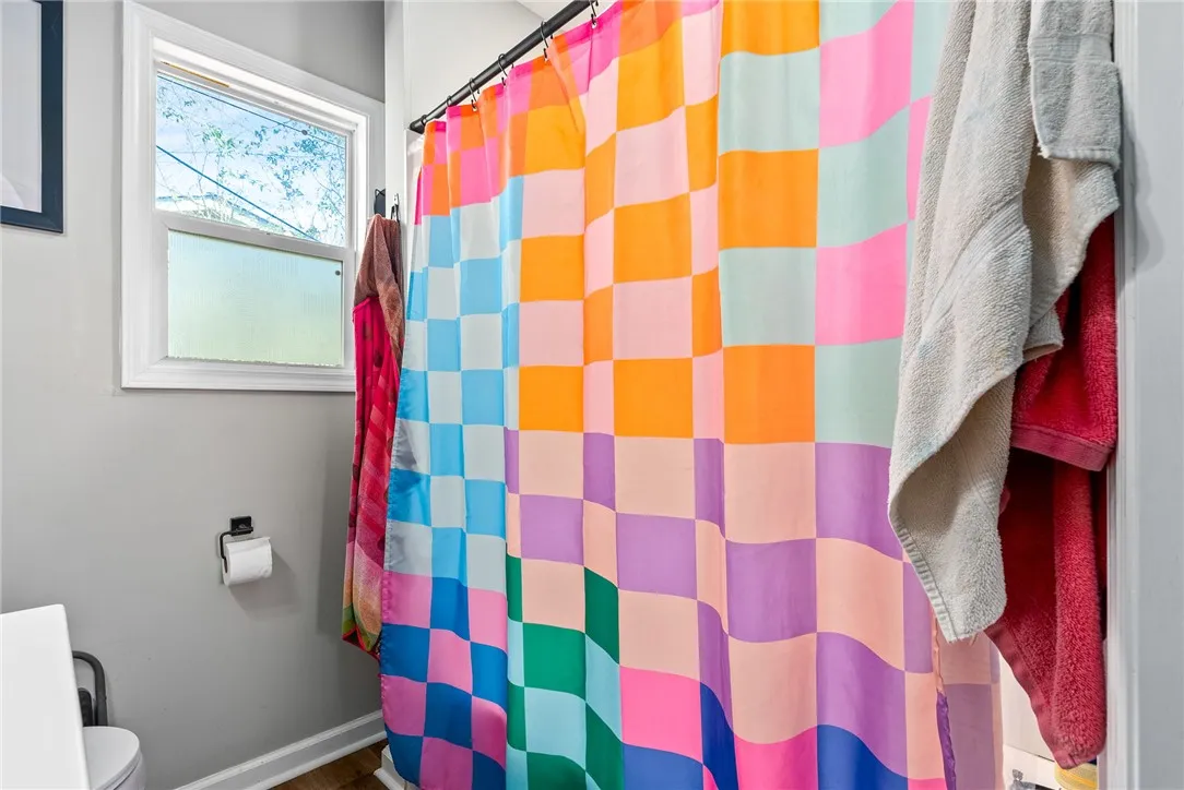Bright bathroom with a checkered shower curtain for a touch of lively color.
