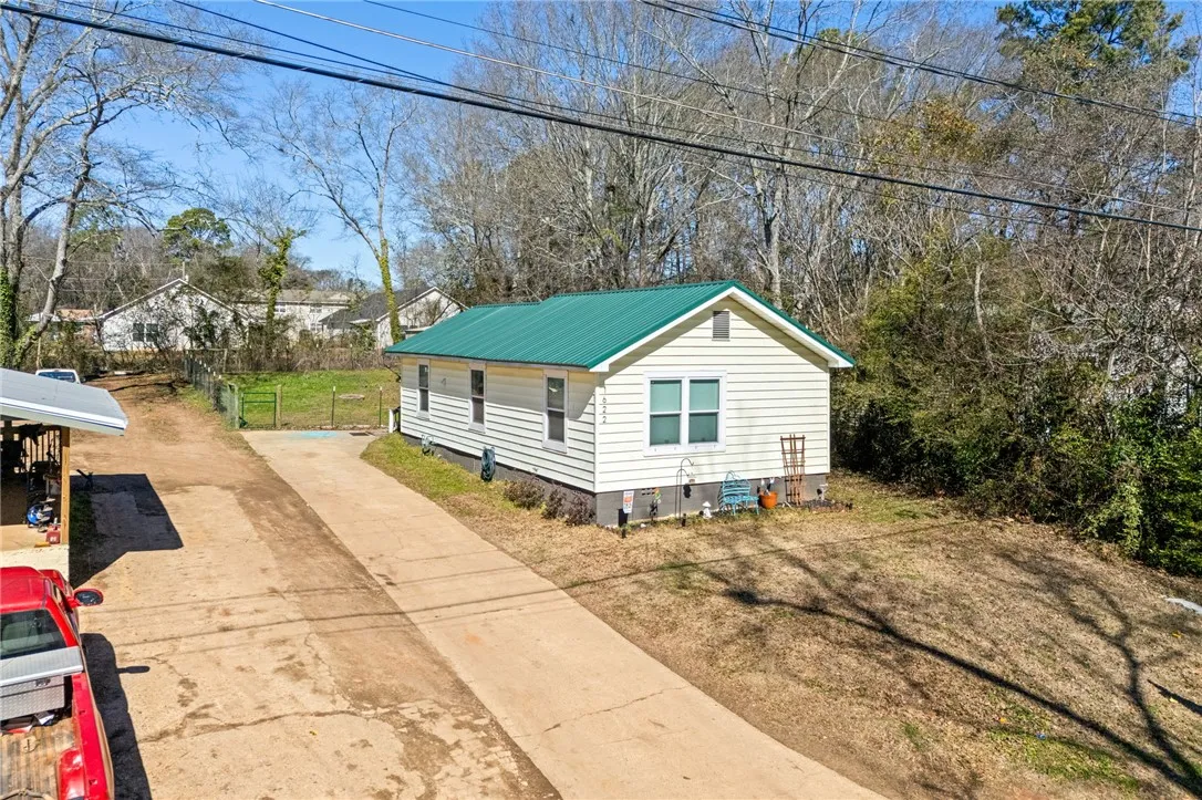 A well-maintained single-story residence with a vibrant green metal roof offers charming curb appeal.
