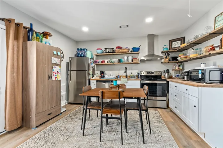 Prepare meals in a kitchen featuring sleek stainless steel appliances and attractive open shelving.