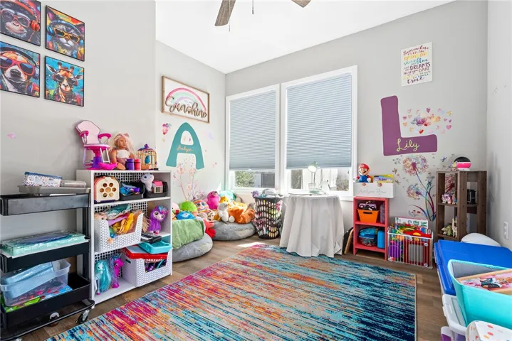 A vibrant playroom offers generous natural illumination and durable hardwood-style flooring, ideal for creative activities.