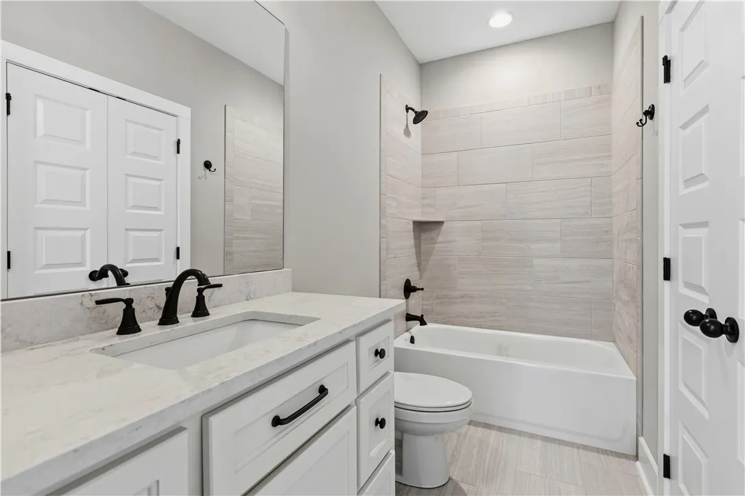 Bathroom on the second floor features a spacious vanity with an integrated sink and a tiled tub and shower.