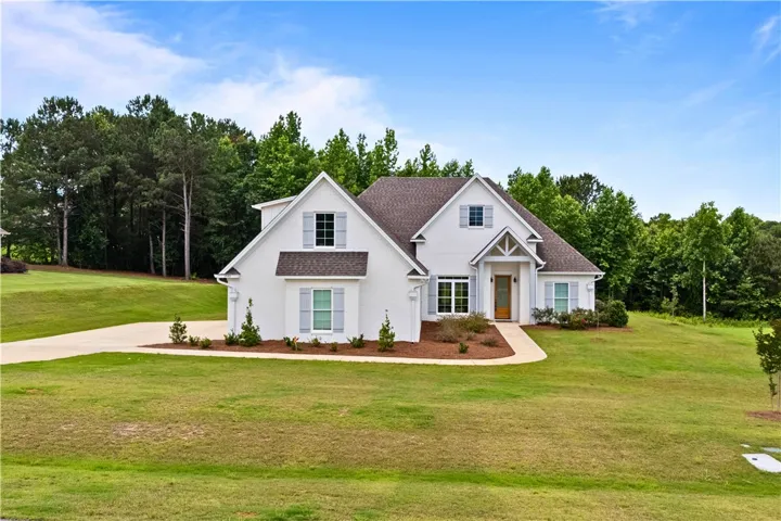 A classic white brick exterior with a welcoming entryway and well-maintained grounds.