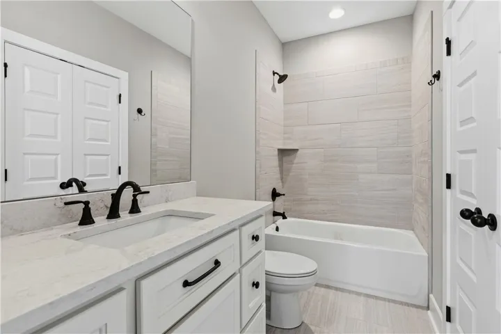 Bathroom on the second floor features a spacious vanity with an integrated sink and a tiled tub and shower.