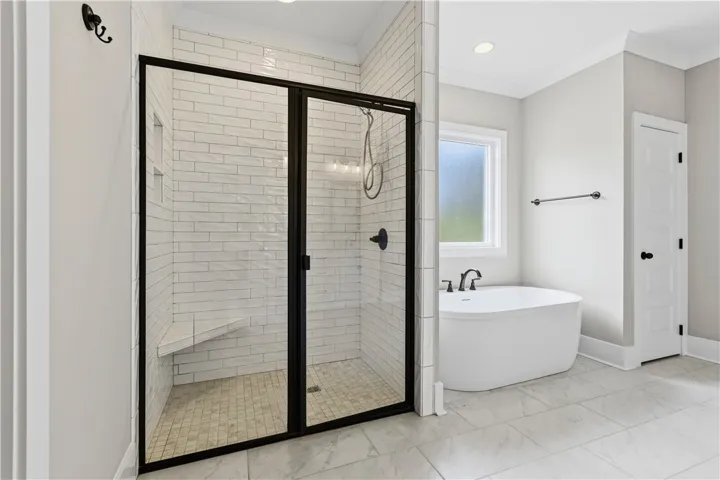 A well-appointed bath features a tiled shower enclosure and a freestanding soaking tub.