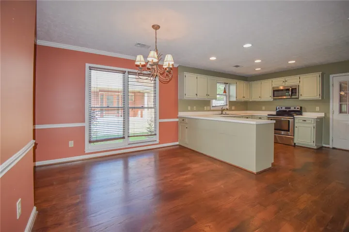 A well-appointed kitchen featuring a functional island, hard-surface flooring, and a cheerful atmosphere.