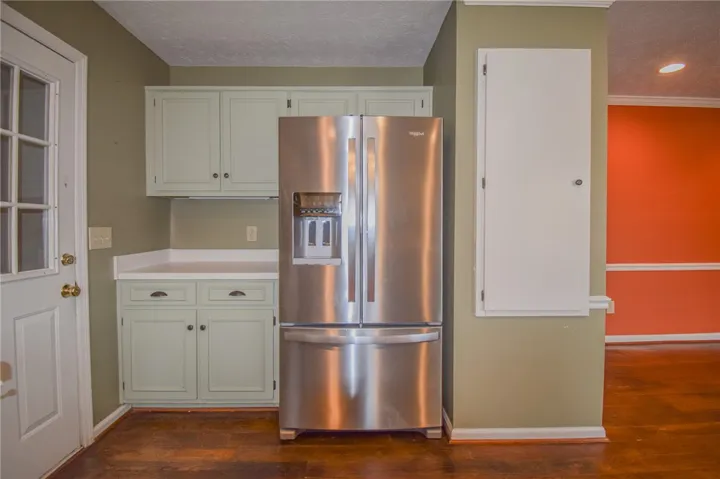 A well-equipped kitchen space features a prominent stainless steel refrigerator and ample cabinetry.