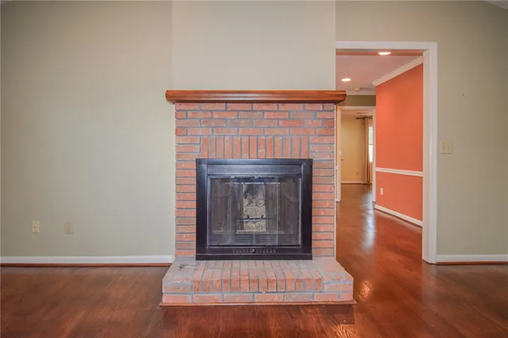 A striking brick fireplace with a wood mantle anchors this open living space.
