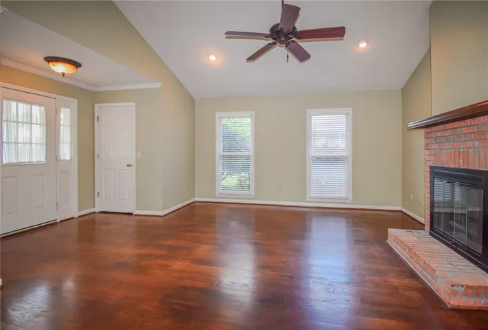 A living area features a classic brick fireplace and rich hardwood flooring, perfect for cozy gatherings.
