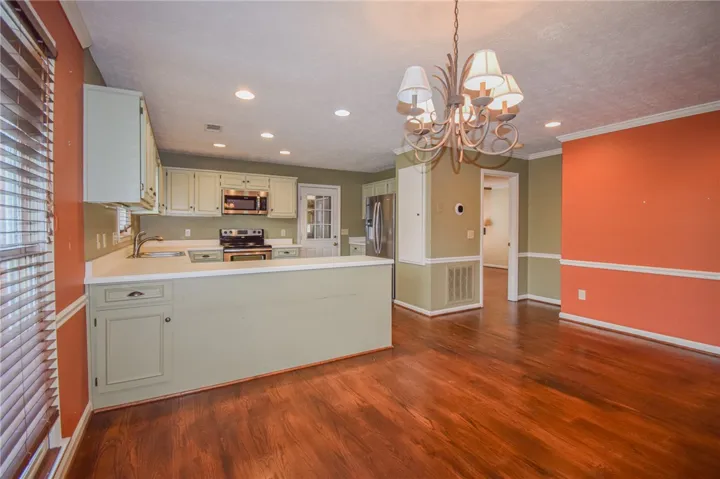 Rich hardwood floors unite an open concept kitchen and dining space.