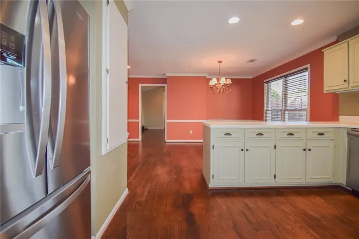A streamlined kitchen layout featuring a large central island and rich hardwood flooring.