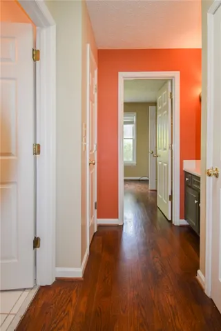 A rich wood floor draws you through this inviting interior hallway, showcasing warm wall tones.