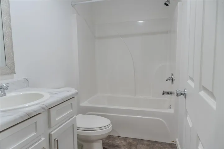 A well-appointed bathroom offers a clean tub-shower combination, modern vanity, and practical flooring.
