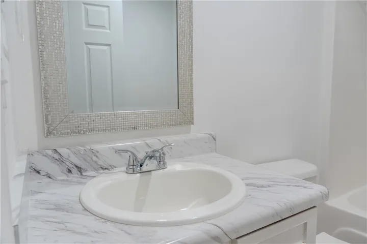 A well-appointed bathroom features a practical vanity and a classic framed mirror.