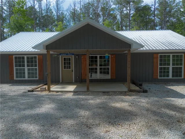 A charming cottage-style exterior features a covered entry, board and batten siding, and a durable metal roof.