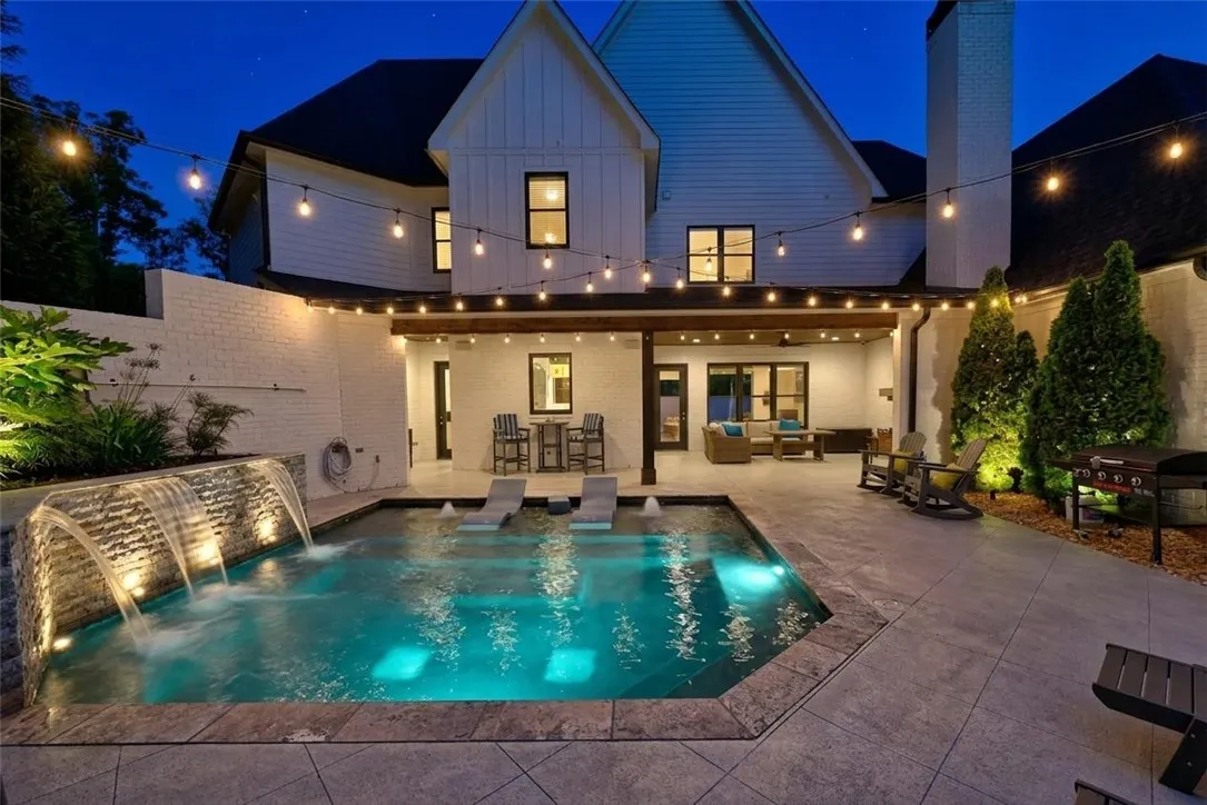 Heated saltwater pool includes multiple water features, tanning ledge, and wrap-around bench!