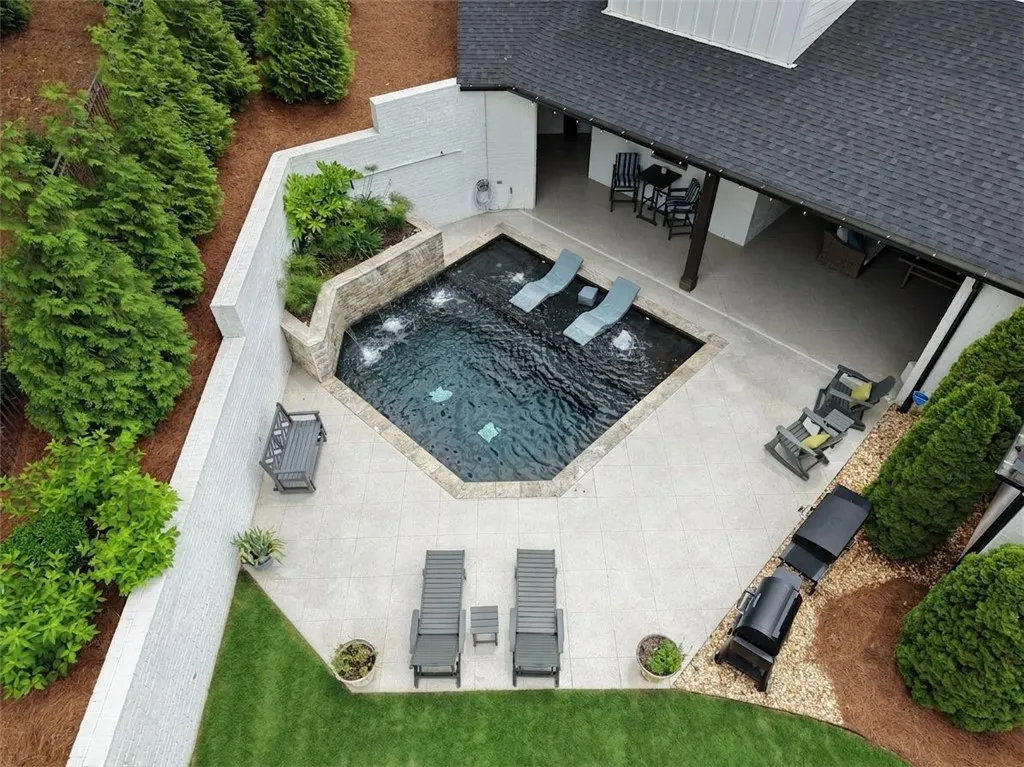 Private and tranquil backyard oasis features a glistening pool with cascading waterfalls and ample leisure space.
