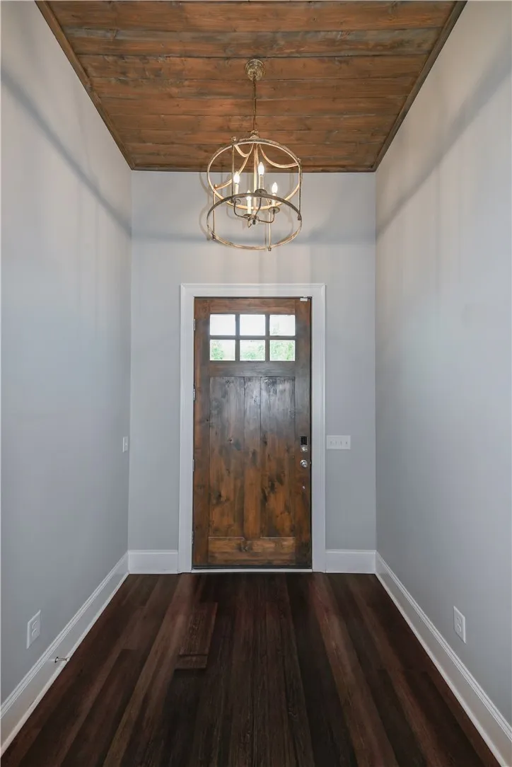 Welcoming entryway with custom wood-plank ceiling that continues into the great room.