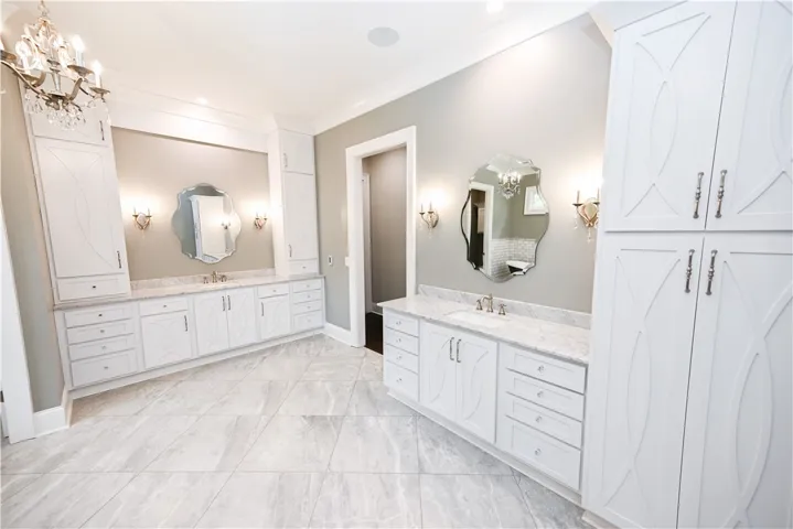 Dual vanities. Marble countertops. Glittering chandeliers. This bath is the definition of luxury!