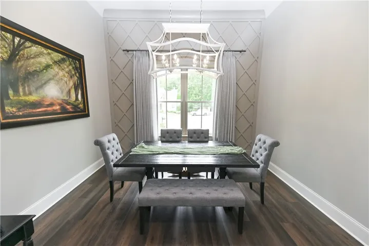 High ceilings and a lovely chandelier beautifully complement the accent wall in this elegant dining room, perfect for entertaining.