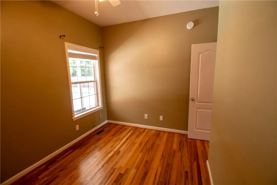 Rich hardwood floors create a welcoming atmosphere in this adaptable room.