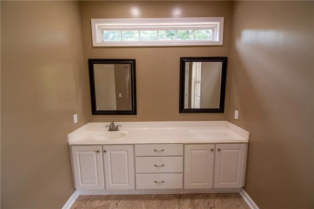Double vanity with ample counter space and framed mirrors offers both practicality and charm in this bathroom.