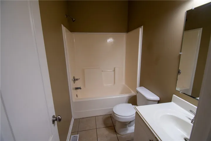 Functional full bathroom featuring a tub/shower combination and a single vanity.