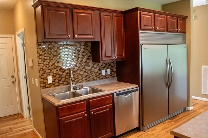 A well-appointed kitchen features rich cabinetry, stainless steel appliances, and a captivating tile backsplash.
