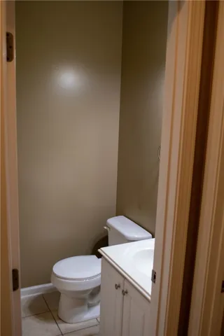 A well-lit half bathroom featuring a functional vanity and toilet.