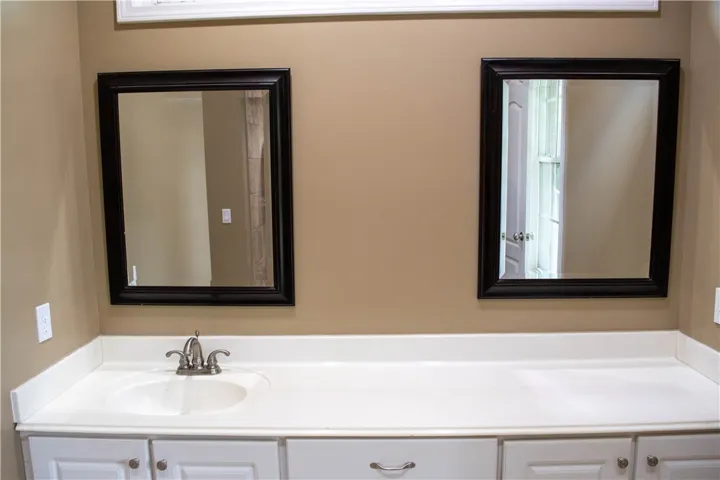 A well-appointed bathroom features a practical vanity with a single sink and dual mirrors.