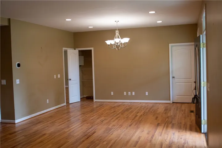 Golden hardwood floors extend across this versatile room, perfect for dining or an open living area.