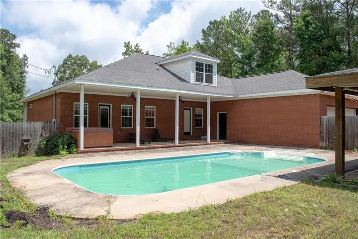 An inviting swimming pool and covered patio extend the living space for outdoor enjoyment.