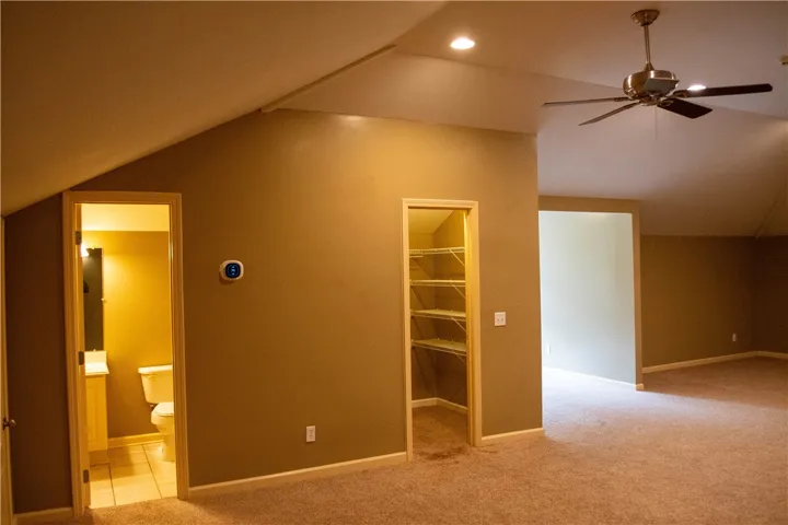 Ample closet space, a ceiling fan, and sloped ceilings define this versatile interior area.