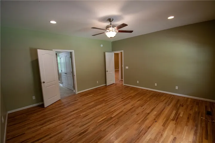 Lustrous hardwood floors and a ceiling fan create a comfortable atmosphere.