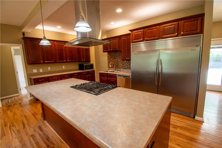 A well-appointed kitchen showcasing a central island cooktop and rich cabinetry.