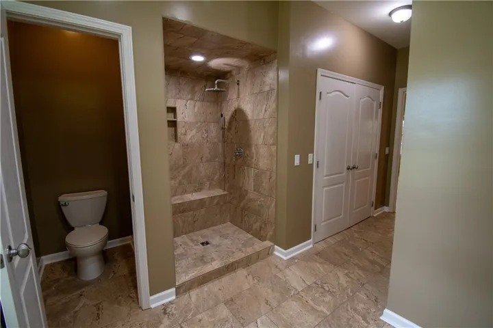 A generously proportioned bathroom with a tiled walk-in shower and separate water closet.