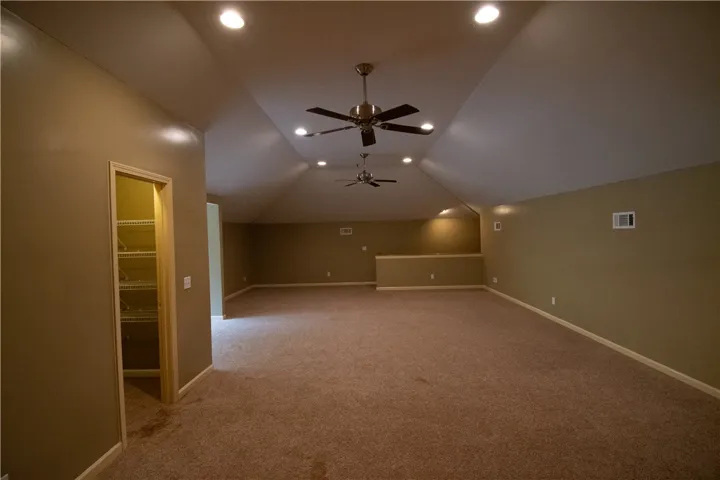 Ample attic space offers versatility with recessed lighting and twin ceiling fans for comfort.