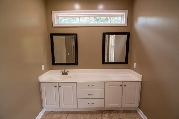 Double vanity with ample counter space and framed mirrors offers both practicality and charm in this bathroom.